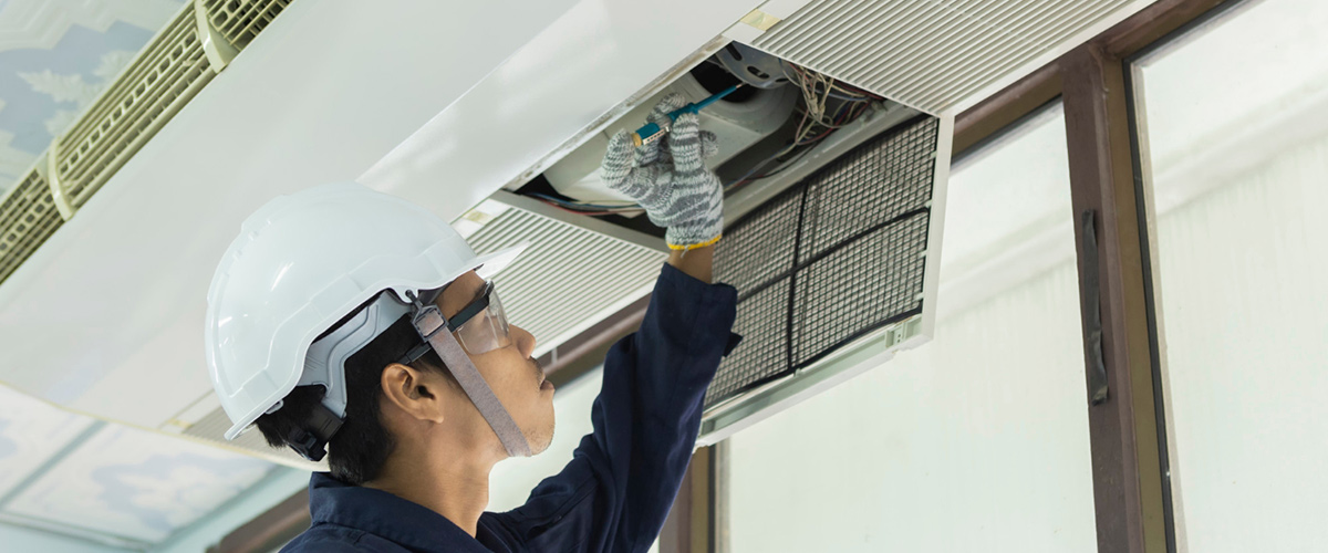 air conditioner repair man checking air conditioning system