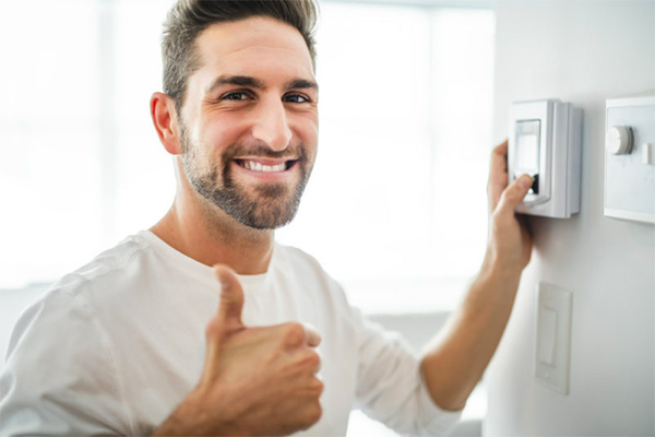 Man using a programmable thermostat