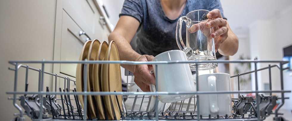 man removing dishes from dishwasher
