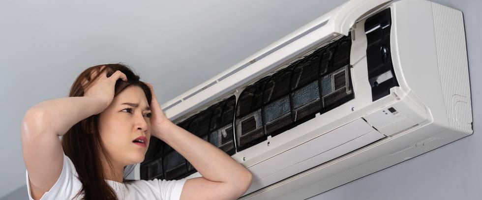 stressed woman has problem with air conditioner