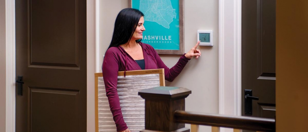 westminster woman adjusting thermostat