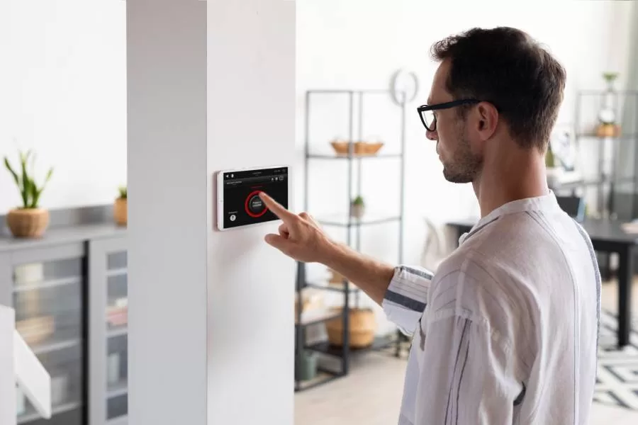 man adjusting thermostat to energy-saving setting