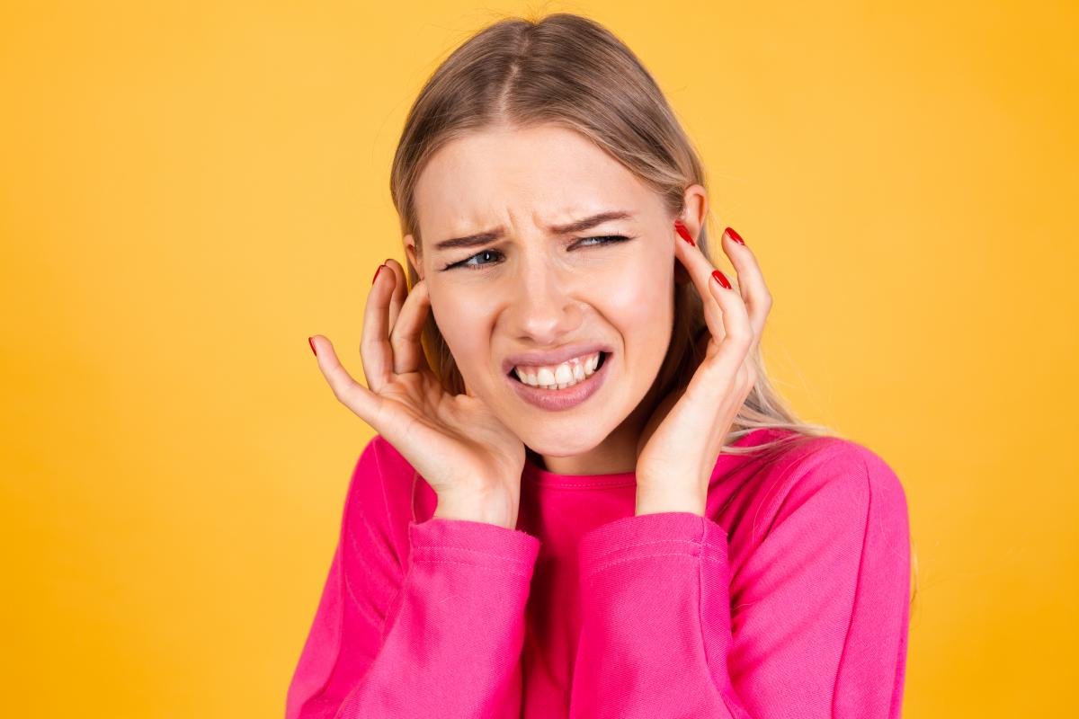 Swamp Cooler Vs Air Conditioner Comparison Guide 2 Swamp Cooler Vs Air Conditioner Comparison Guide pretty european woman pink blouse yellow wall covering ears loud noise from ac unit