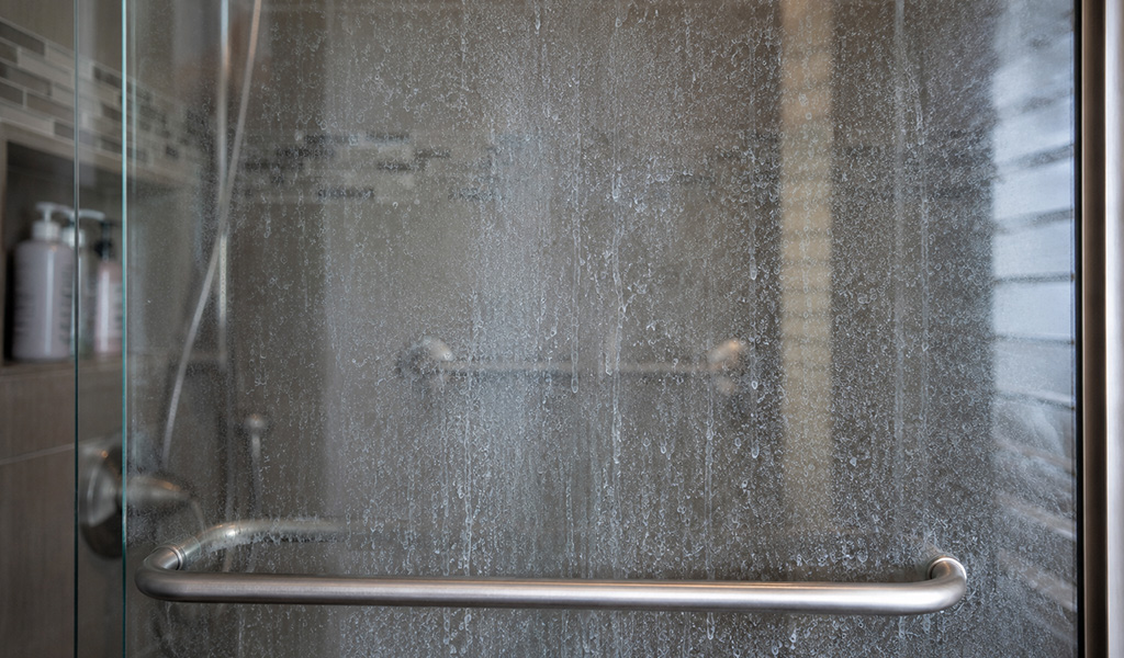 Hard water spots and mineral film on a shower door